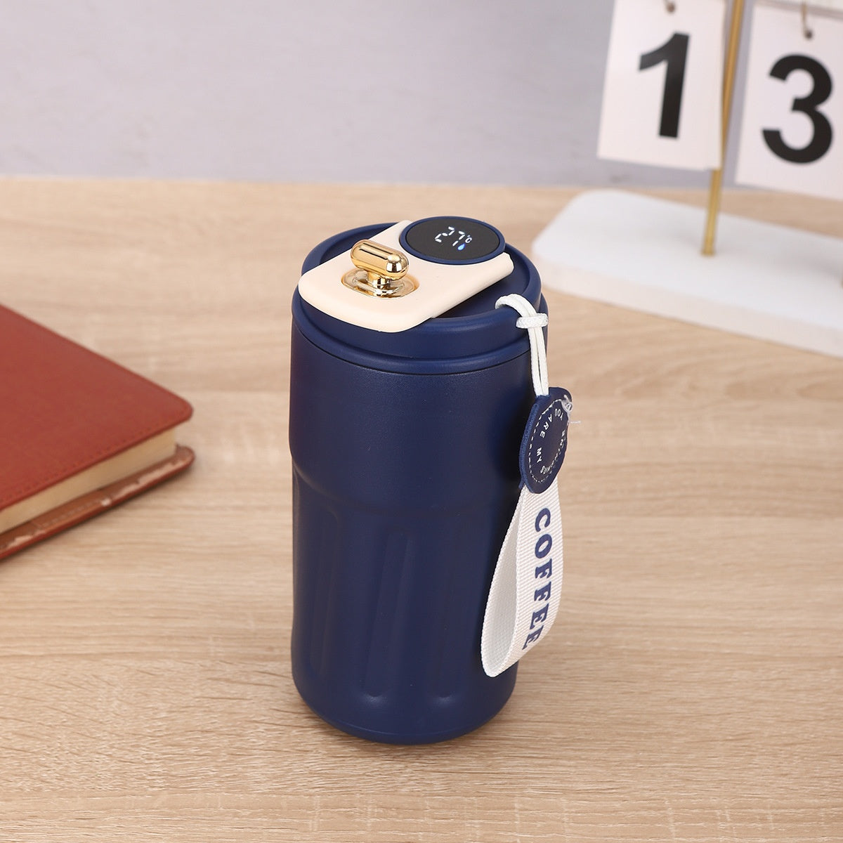 Blue thermos with a white label on a wooden surface.