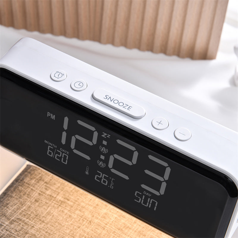 Digital clock with time display on a bed.
