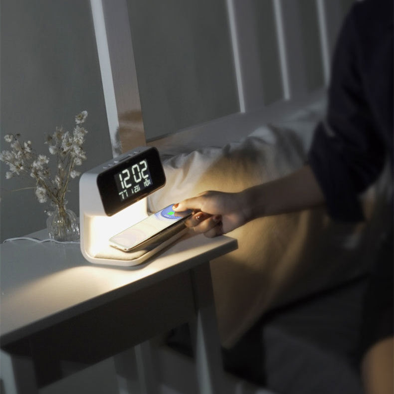 Smart night light with digital display on a bedside table, women using phone.