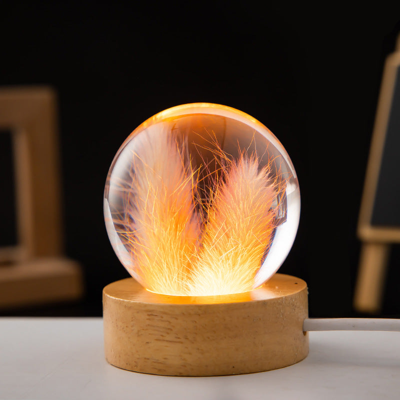 Glass sphere with fiery interior on a wooden base against a dark background
