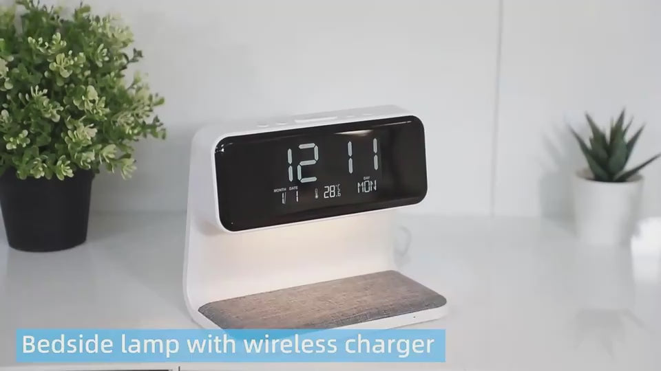 Detailed view of lamp with clock and phone being charged while switching on and off.