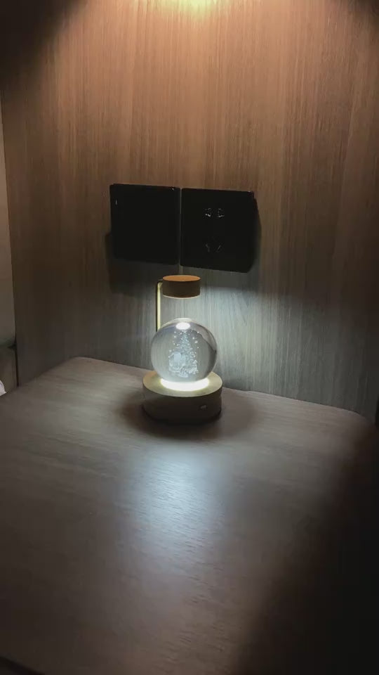 Desk lamp sphere with tree inside glowing in dark corner.