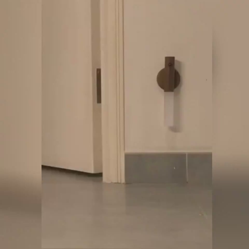 LED lamp attached to wall, illuminated and charging through USB.