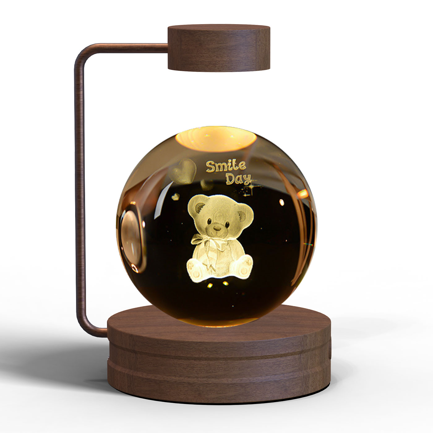 Levitating glass ball with a teddy bear inside, featuring the text «Smile Day» on wooden stand.