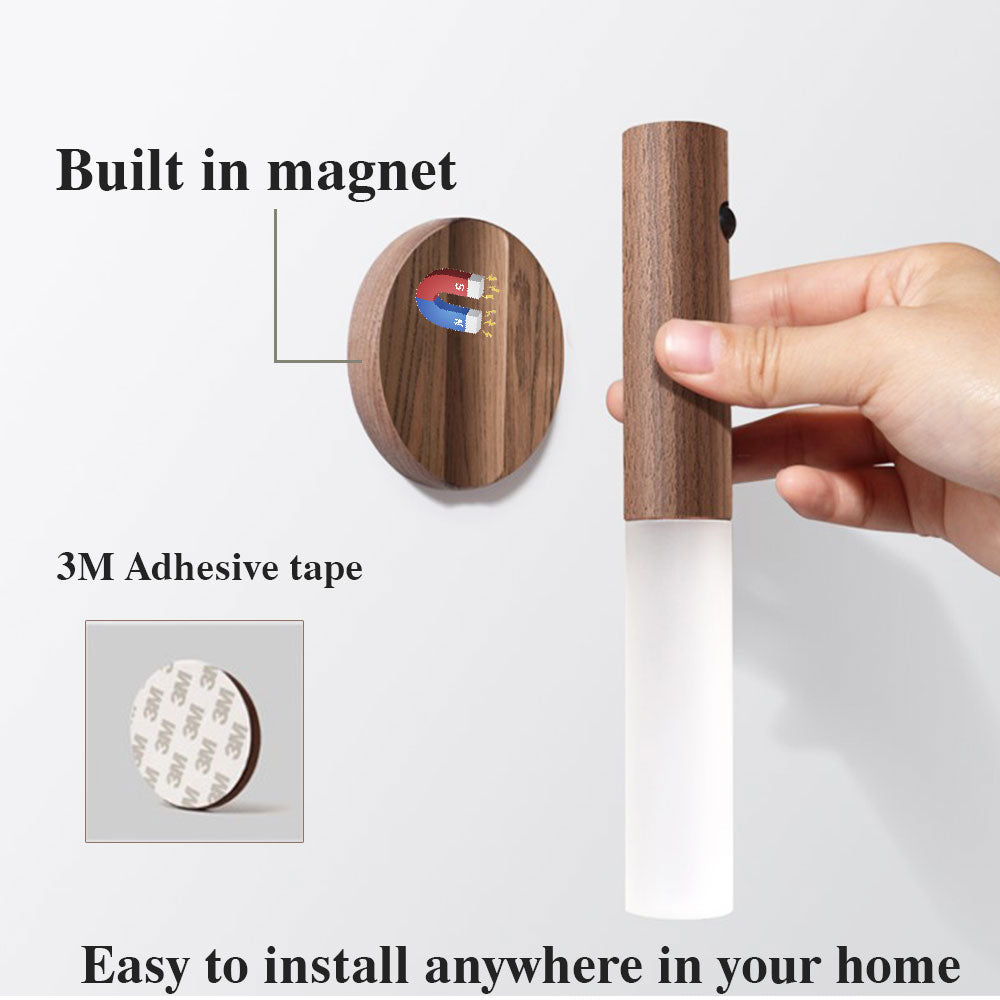 Wooden wall hook with magnetic and adhesive features, held by a hand on white background.
